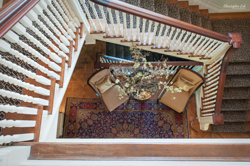 Christopher Luk - Toronto Wedding Portrait Event Photographer - Graydon Hall Manor - Staircase Overhead View Banister Chairs Floral Arrangement Side Table Persian Rug Carpet