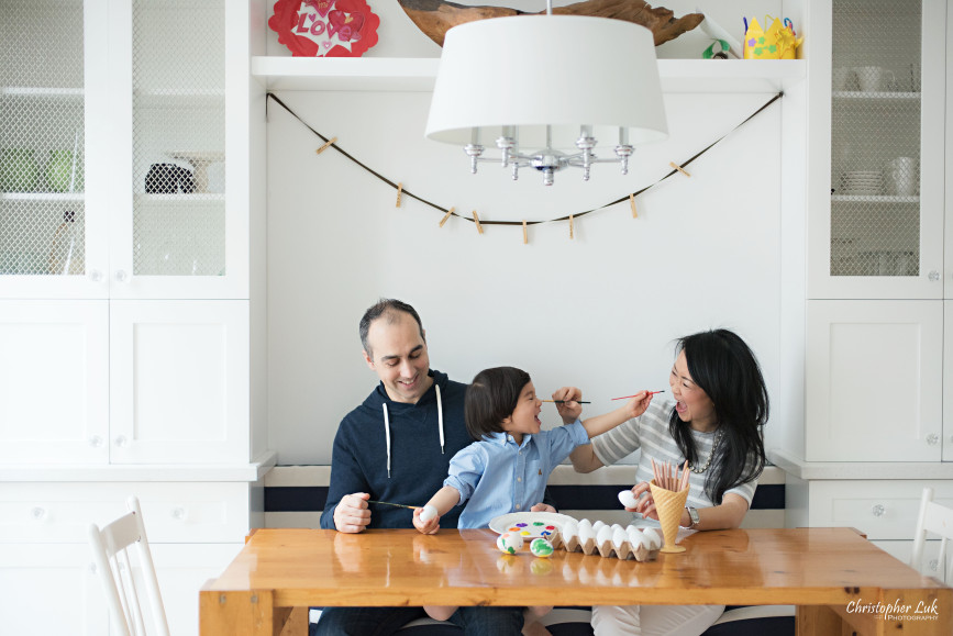 Christopher Luk 2015 - Toronto Family Toddler Winter Spring Indoor Home Session - Mom Dad Toddler Son Boy Blue Shirt Fashion White Kitchen Bench Chairs Wood Table Children Lifestyle Egg Painting Fun Activity Paintbrush Faces