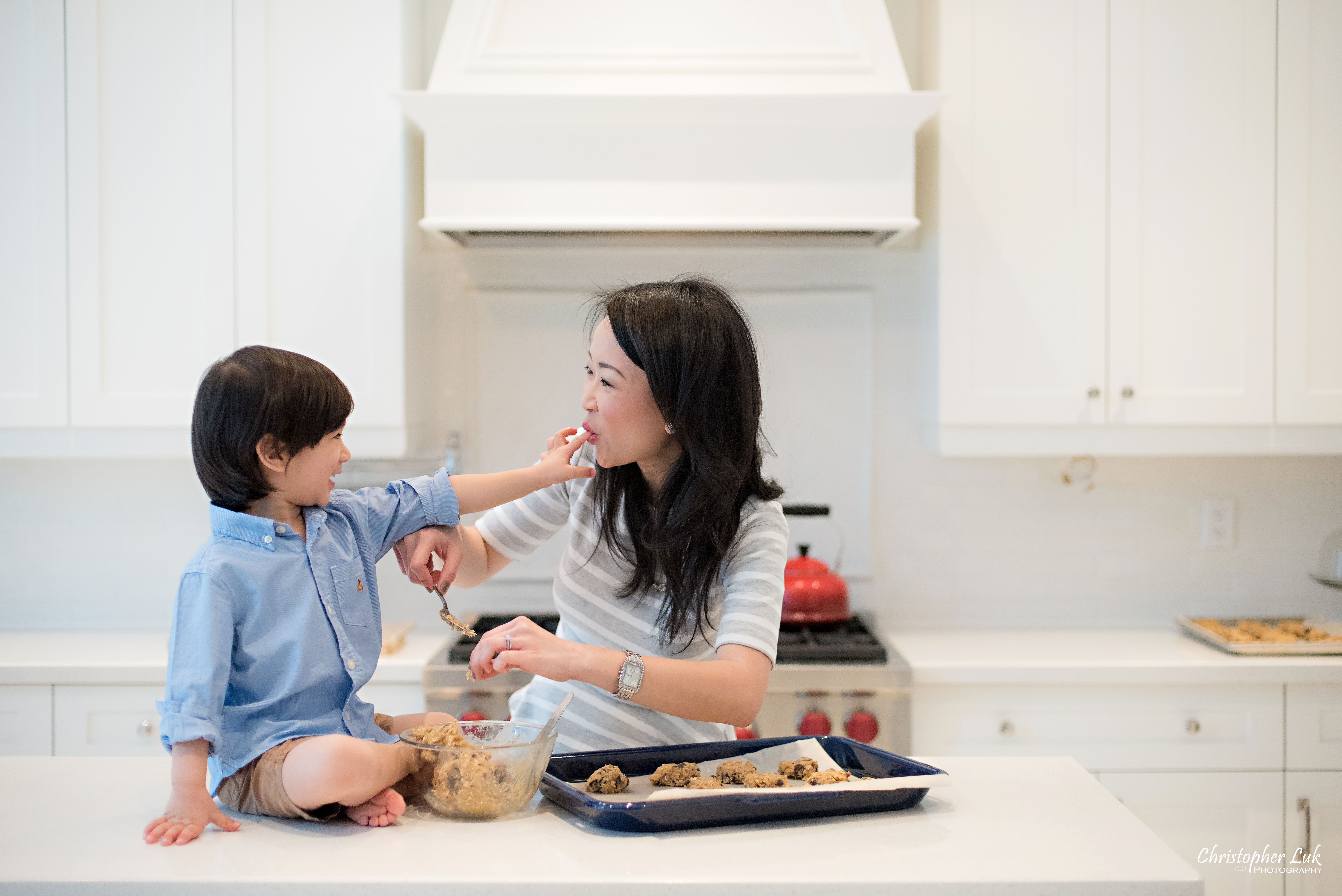 Christopher Luk 2015 - Toronto Family Toddler Winter Spring Indoor Home Session - Mom Toddler Son Boy Blue Grey White Striped Shirt Fashion Children Lifestyle Kitchen Centre Island Fun Candid Photojournalistic Finger Licking Cute