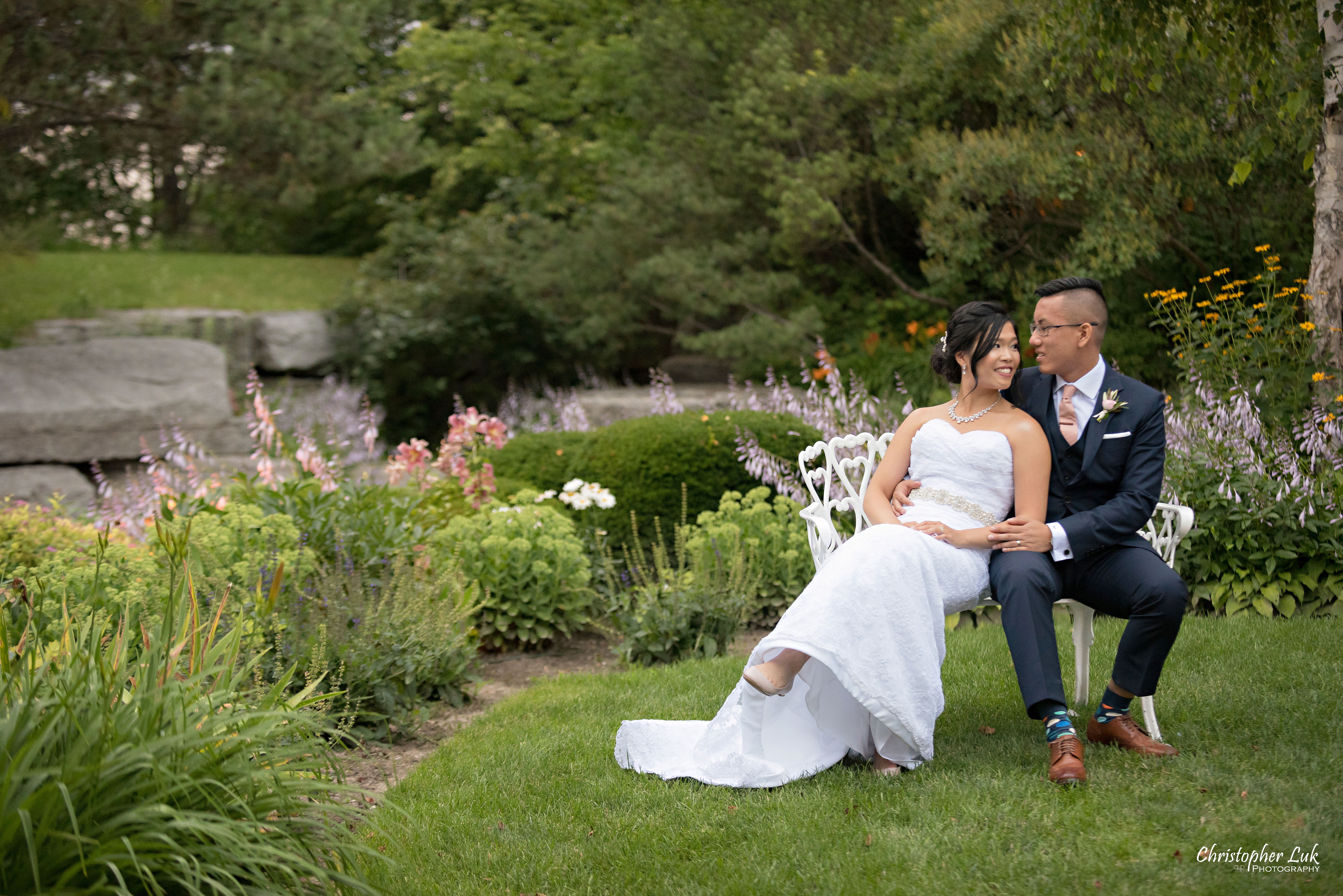 Christopher Luk - Toronto Wedding Photographer - The Manor Event Venue By Peter and Paul's - Main Grand Entrance Trees Walkway Painted White Cast Wrought Iron Bench Seat Bride Groom Golden Hour Creative Portrait Session Natural Candid Photojournalistic Seated Sitting Hug Smile