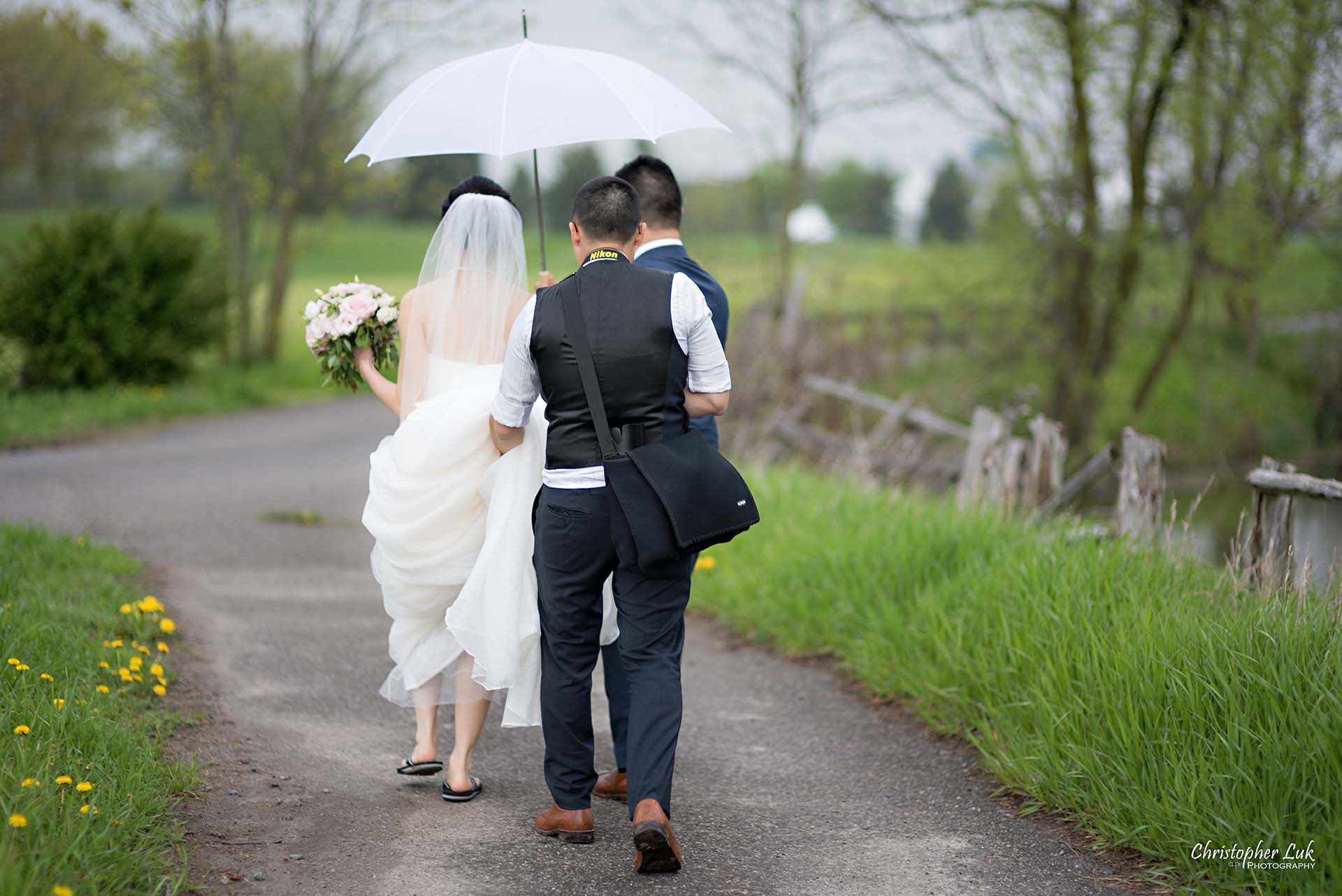 Christopher Luk Toronto Wedding Photographer Behind the Scenes Angus Glen Golf Club Markham Bride Groom Rain Umbrella Walking Together