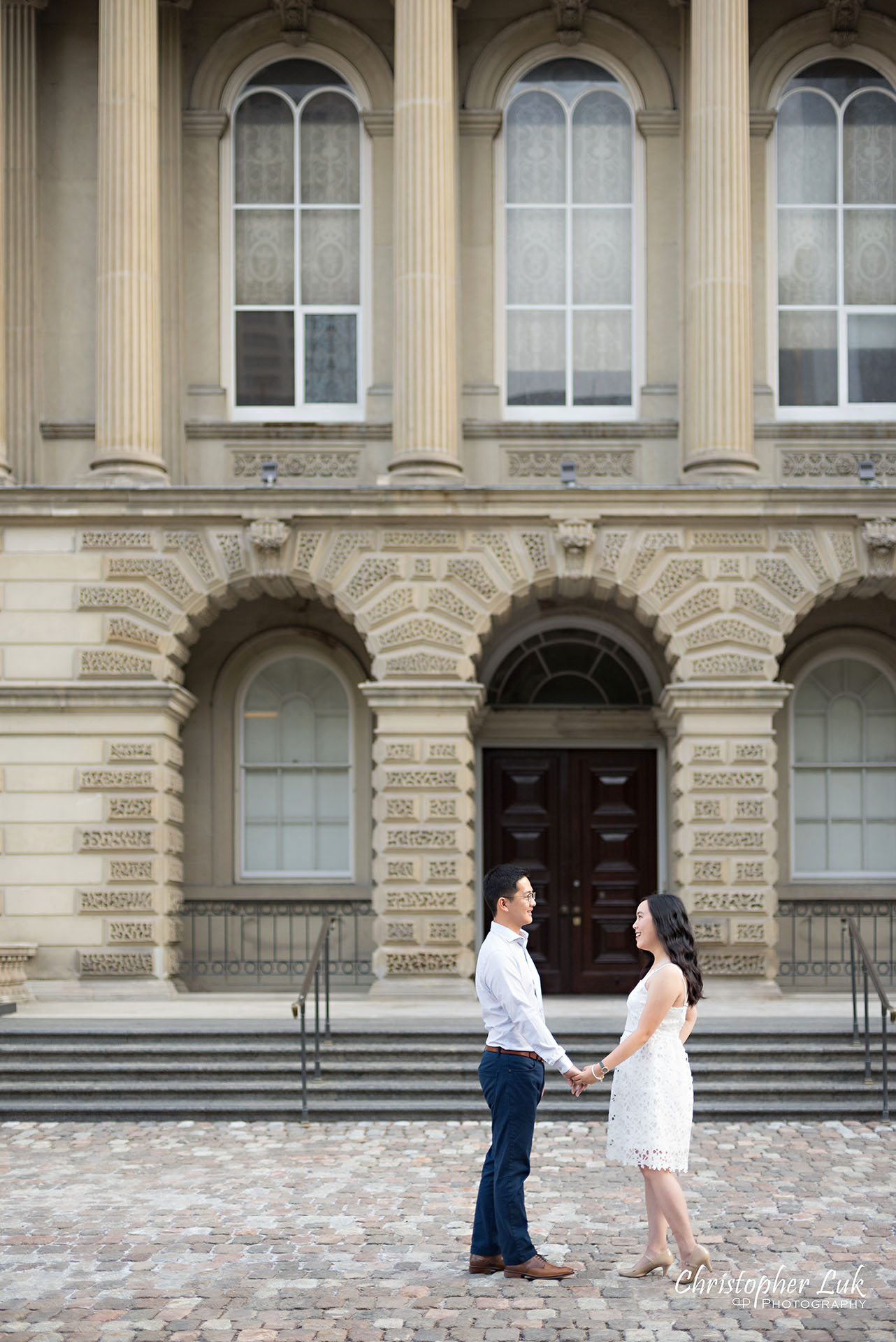 Christopher Luk Wedding Photographer Osgoode Hall Toronto Bride Groom Main Historic Building Front Cobblestone Holding Hands Walking Together Looking at Each Other PortraitChristopher Luk Wedding Photographer Osgoode Hall Toronto Bride Groom Main Historic Building Front Cobblestone Holding Hands Walking Together Looking at Each Other Portrait Natural Candid Photojournalistic