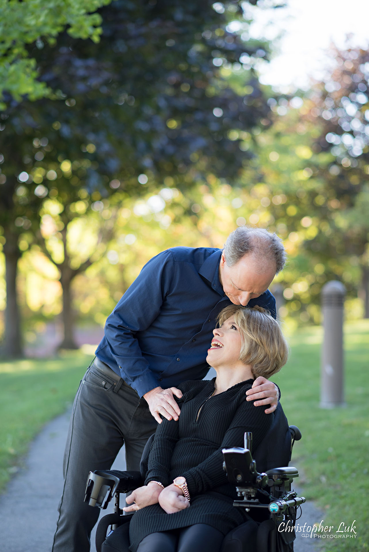 Christopher Luk Toronto Wedding Photographer Whitby Durham Engagement Session Bride Groom Candid Natural Photojournalistic Wheelchair Path Pathway Hug Wrap Arms Standing