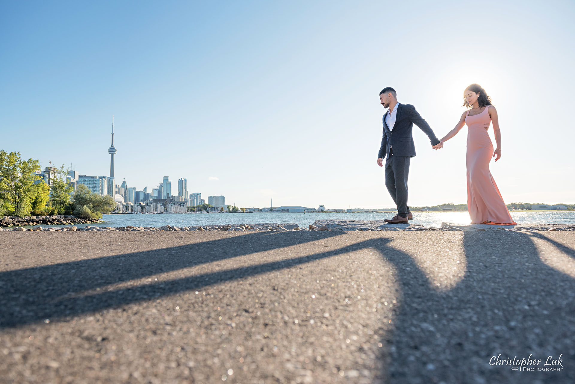 Christopher Luk Trillium Park Ontario Place Waterfront Engagement Session Toronto Wedding Photographer Bride Groom Natural Candid Photojournalistic CN Tower Skyline Background Sunrise Walkway Pathway Shadows