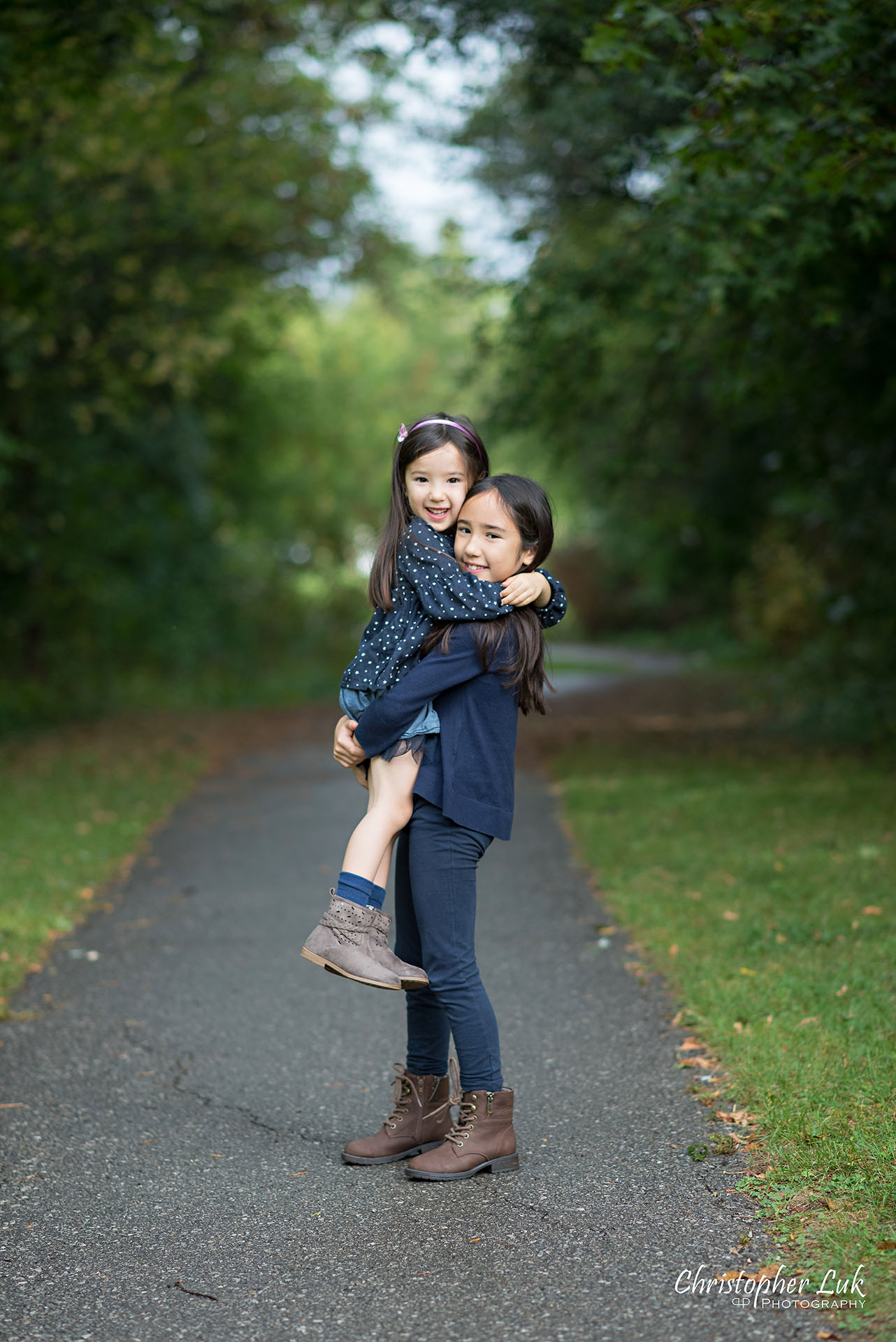 Christopher Luk Family Photographer Toronto Markham Candid Natural Photojournalistic Daughters Sisters Sisterhood Smile Hug Carry Lift Cute Adorable
