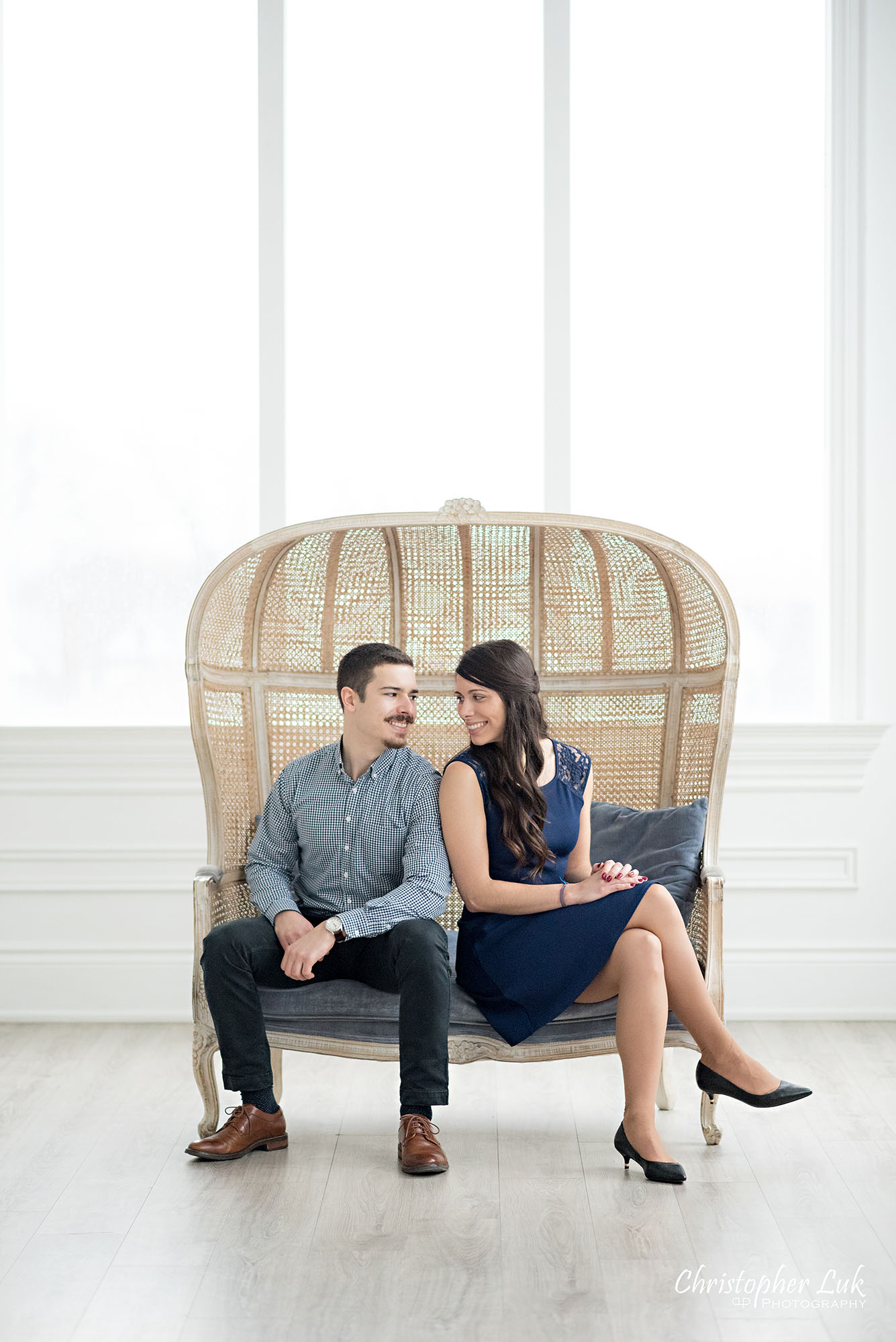 Christopher Luk Toronto Wedding Photographer Mint Room Studios Conservatory Engagement Session Winter Indoor Natural Light Candid Photojournalistic Bride Groom Wicker French Rustic Vintage Dome Loveseat Chair Looking at Each Other Lovingly