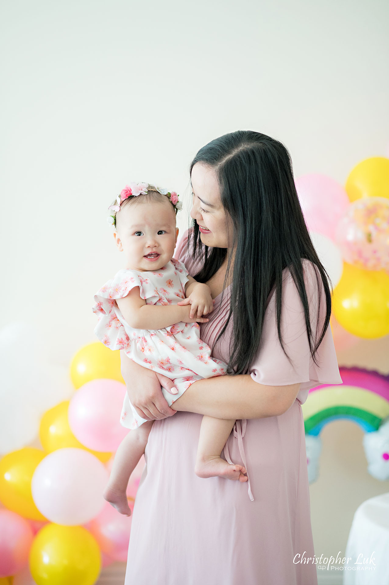 Christopher Luk Toronto Markham Family Photographer Baby Girl First Birthday Balloon Arch Rainbow Pink Sun Clouds Decor Mother Mom Daughter Motherhood Hug Smile Laugh Natural Candid Photojournalistic Portrait