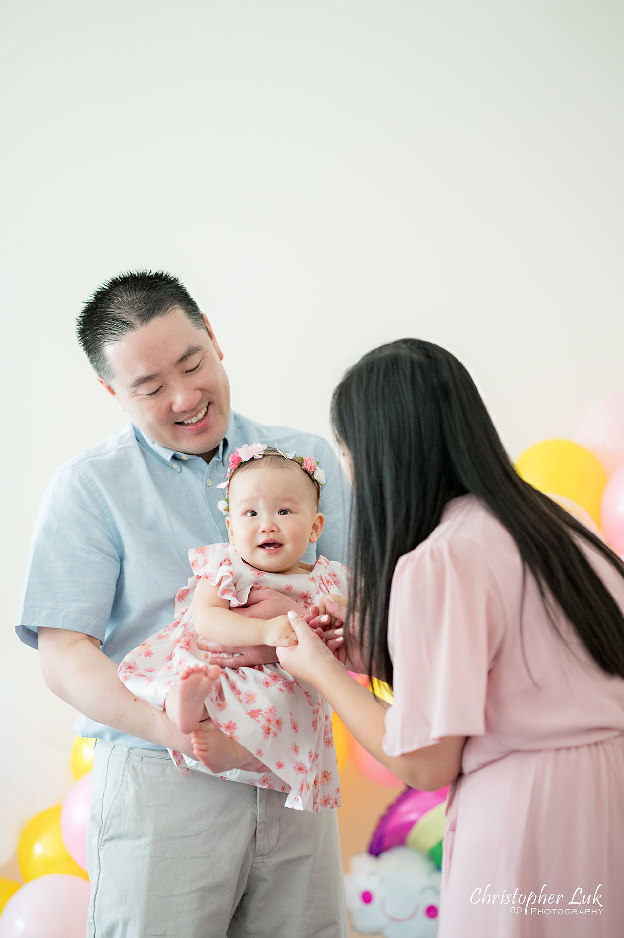 Christopher Luk Toronto Markham Family Photographer Baby Girl First Birthday Balloon Arch Rainbow Pink Sun Clouds Decor Mother Mom Daughter Motherhood Father Dad Fatherhood Hug Smile Play Together Laugh Natural Candid Photojournalistic Portrait