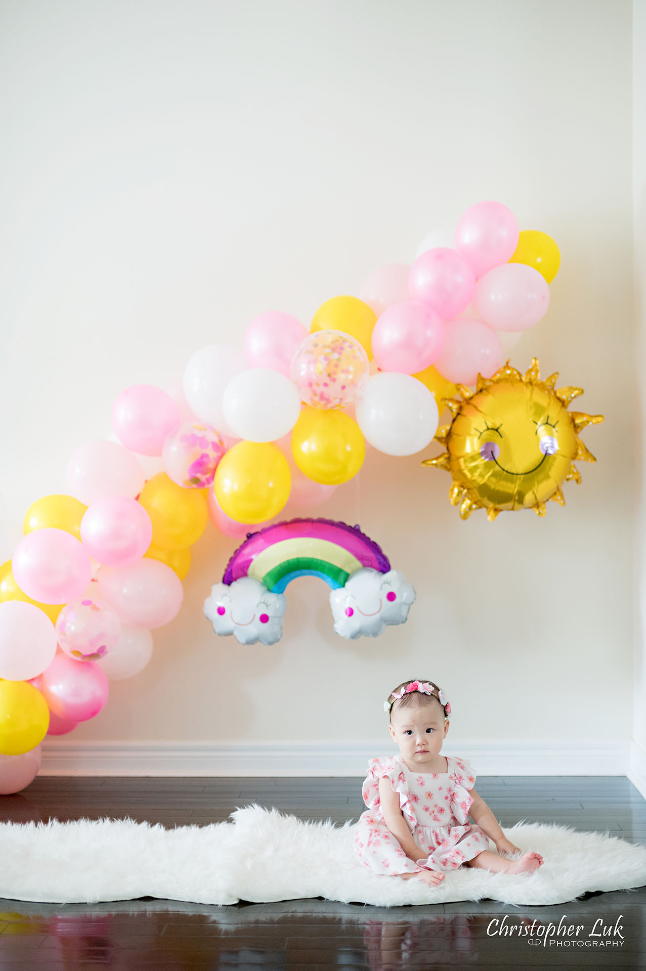 Christopher Luk Toronto Markham Family Photographer Baby Girl First Birthday Balloon Arch Rainbow Pink Sun White Fuzzy Fur Rug Mat Natural Candid Photojournalistic Portrait