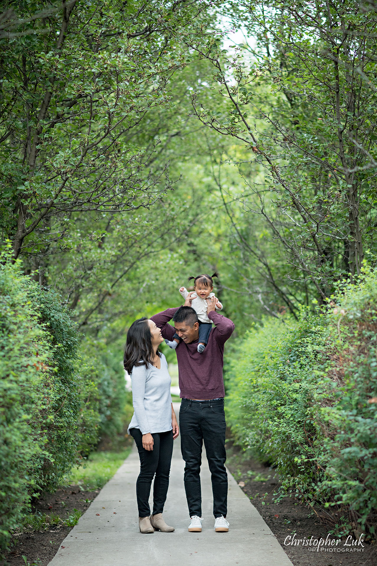 Christopher Luk Toronto Markham Family Wedding Photographer Baby Girl Natural Candid Photojournalistic Mom Dad Mother Father Motherhood Fatherhood Daughter Vertical Portrait Hug Carry Carrying on Shoulders Together Fun Adorable Cute Walking Together Path Pathway