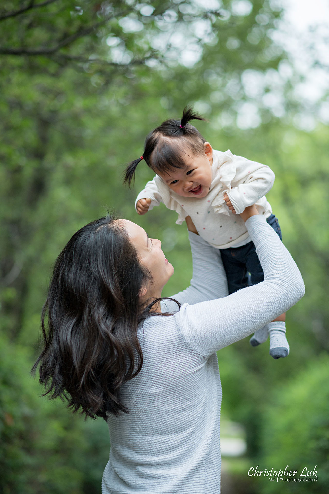 Christopher Luk Toronto Markham Family Wedding Photographer Baby Girl Natural Candid Photojournalistic Mom Mother Motherhood Daughter Lift Up in Air Kiss Fun Vertical Portrait Smiling Laughing