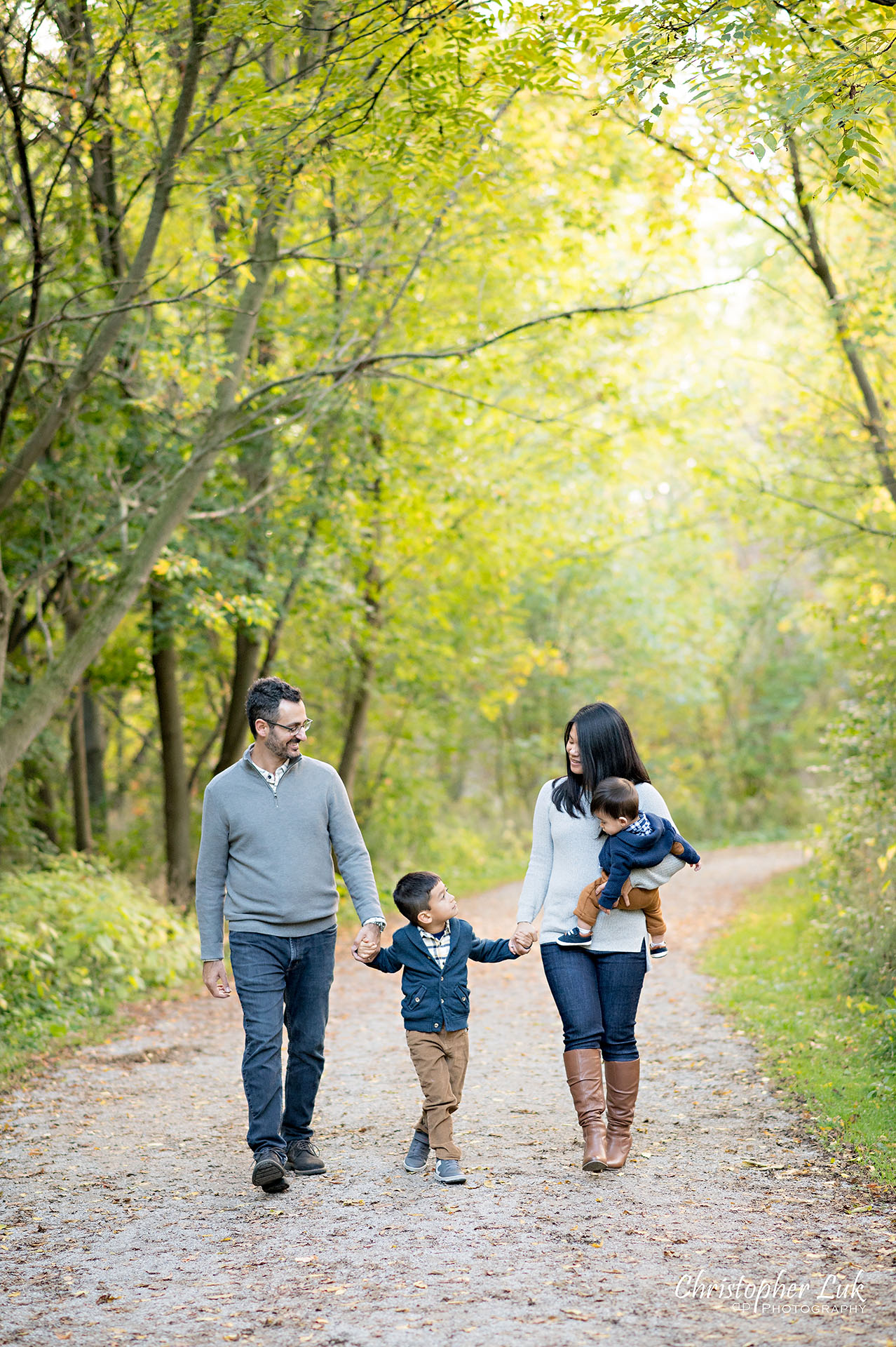 Christopher Luk Family Photographer Toronto Markham Unionville Autumn Fall Leaves Natural Candid Photojournalistic Sons Brothers Baby Boys Father Dad Mother Mom Motherhood Fatherhood Holding Hands Walking Together Trail Pathway Forest Smile