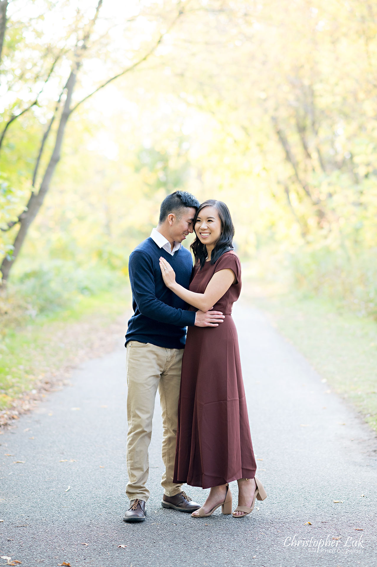 Christopher Luk Toronto Wedding Engagement Session Photographer Autumn Fall Leaves Natural Candid Photojournalistic Bride Groom Hugging Hug Holding Each Other Together Pathway Hiking Trail
