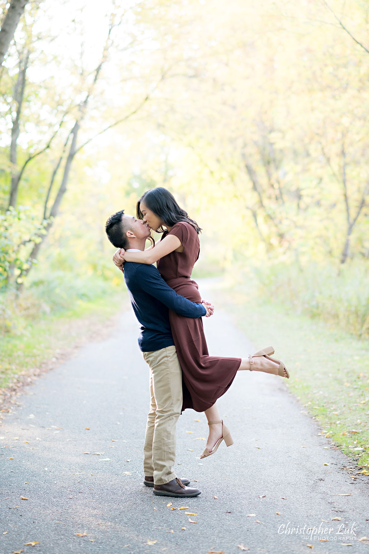 Christopher Luk Toronto Wedding Engagement Session Photographer Autumn Fall Leaves Natural Candid Photojournalistic Bride Groom Holding Hands Walking Together Pathway Hiking Trail Jump Hug Lift Carry Kiss