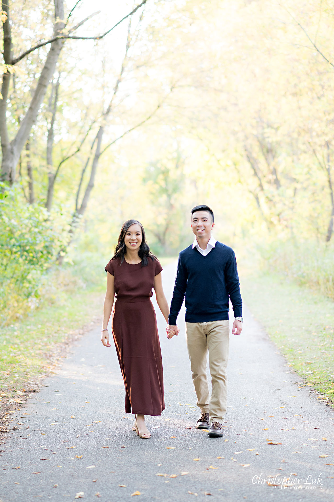 Christopher Luk Toronto Wedding Engagement Session Photographer Autumn Fall Leaves Natural Candid Photojournalistic Bride Groom Holding Hands Walking Together Pathway Hiking Trail