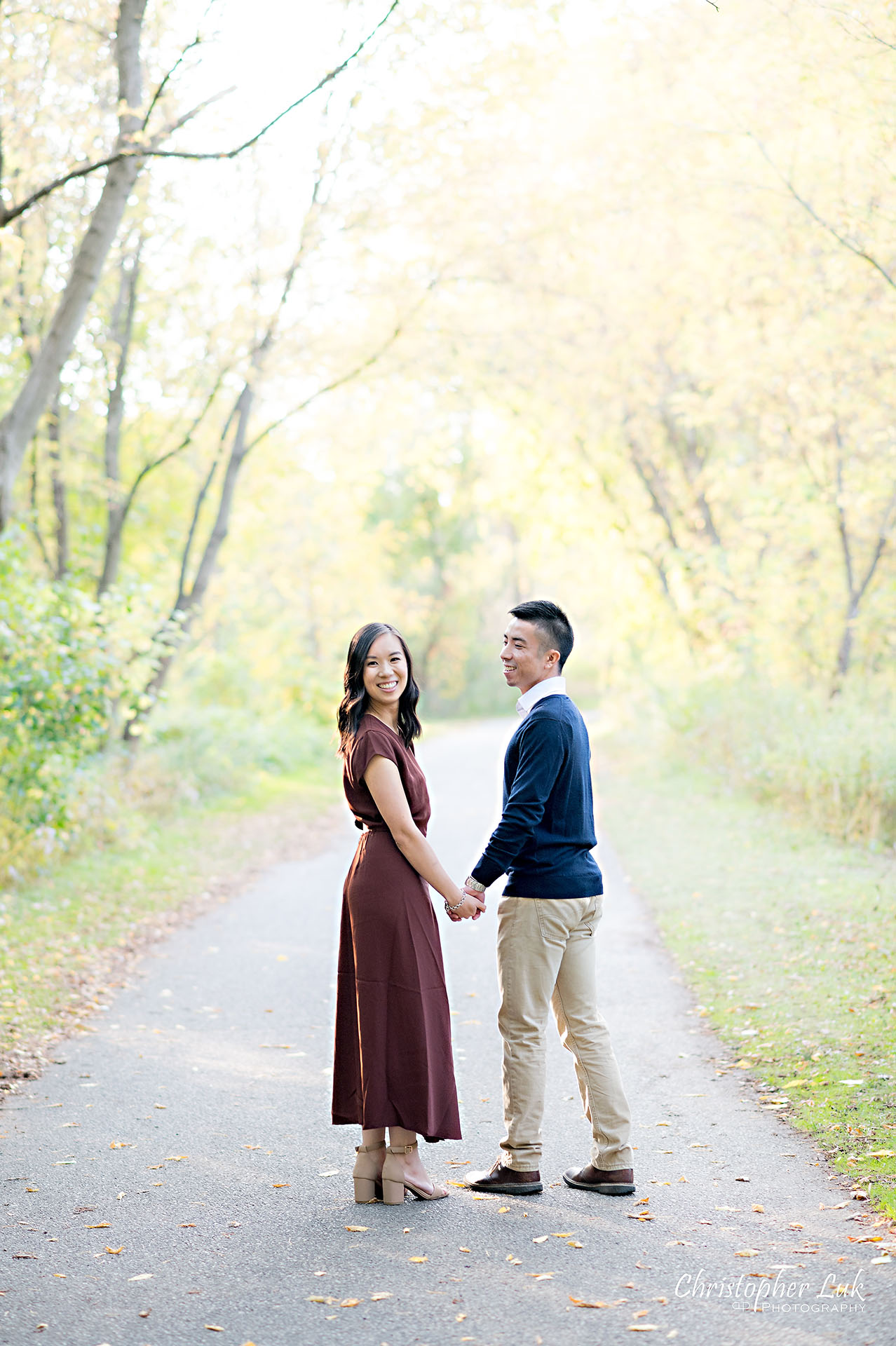 Christopher Luk Toronto Wedding Engagement Session Photographer Autumn Fall Leaves Natural Candid Photojournalistic Bride Groom Holding Hands Walking Together Pathway Hiking Trail