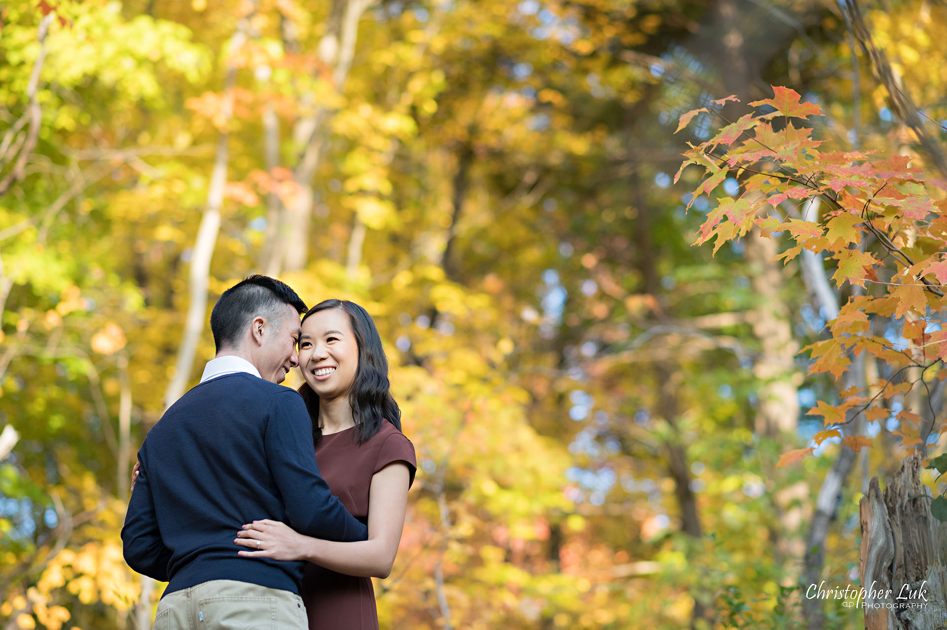 Christopher Luk Toronto Wedding Engagement Session Photographer Autumn Fall Leaves Natural Candid Photojournalistic Bride Groom Hiking Trail Trees Hug Holding Each Other Together Orange Red Yellow