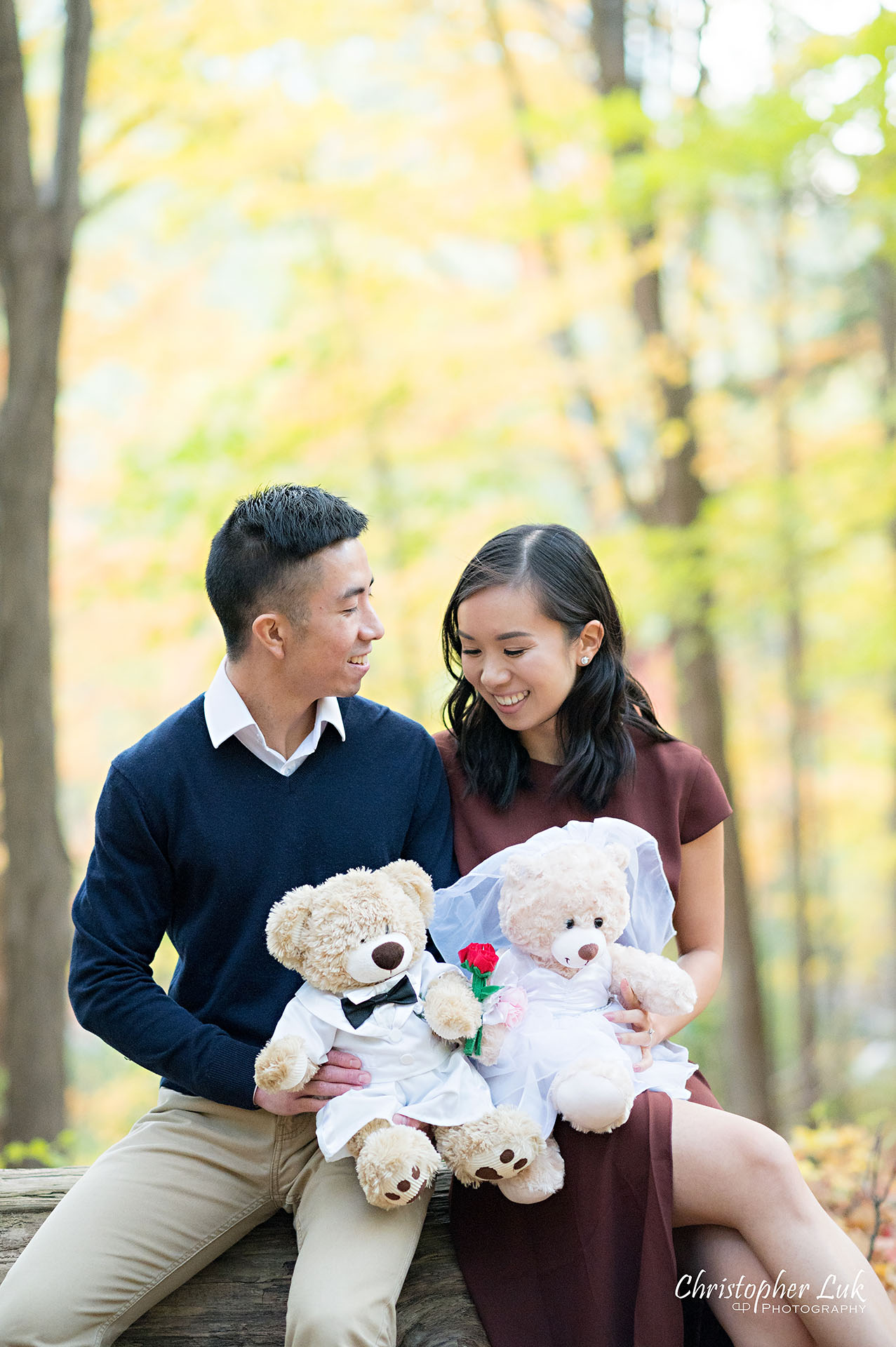 Christopher Luk Toronto Wedding Engagement Session Photographer Autumn Fall Leaves Natural Candid Photojournalistic Bride Groom Hiking Trail Stuffed Animal WongFu Productions Spencer Bear Trees Log Smiling Happy Portrait