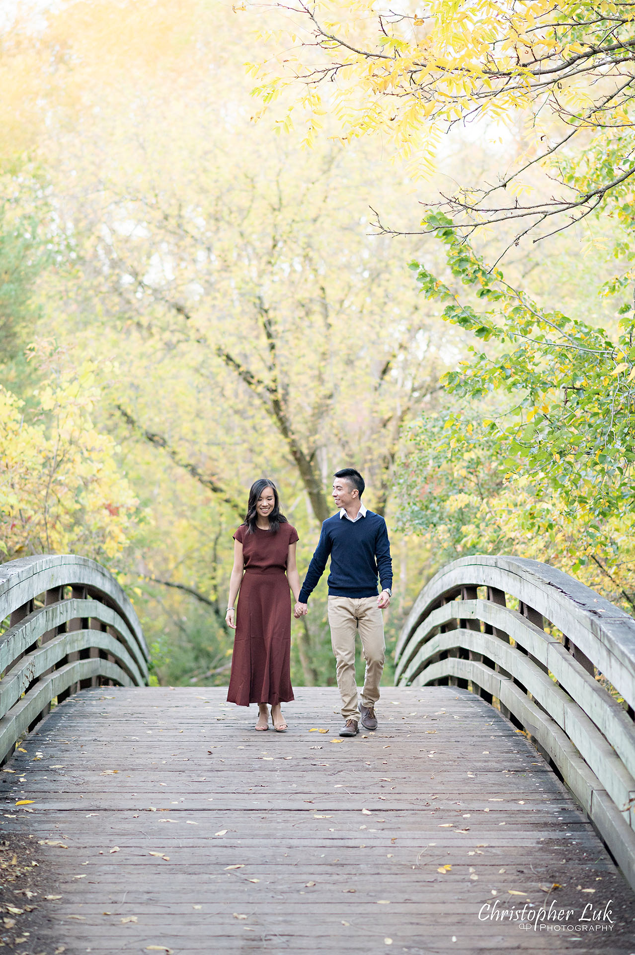 Christopher Luk Toronto Wedding Engagement Session Photographer Autumn Fall Leaves Natural Candid Photojournalistic Bride Groom Bridge Holding Hands Walking Together