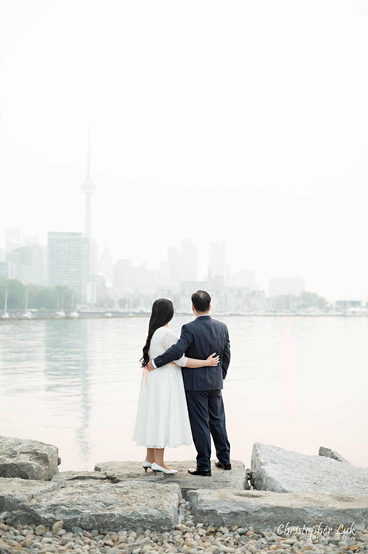 Christopher Luk Toronto Wedding Photographer Trillium Park Engagement Session Ontario Place Waterfront Skyline Natural Candid Photojournalistic Bride Groom Hug Together Loving CN Tower Portrait