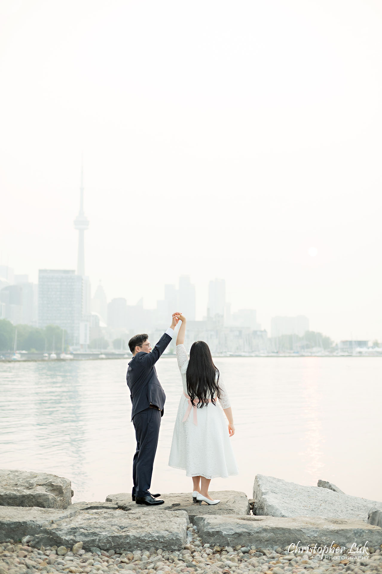 Christopher Luk Toronto Wedding Photographer Trillium Park Engagement Session Ontario Place Waterfront Skyline Natural Candid Photojournalistic Bride Groom Dancing Spinning Together Loving CN Tower