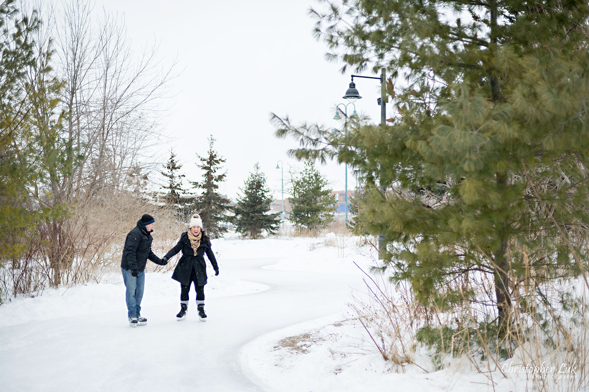 Christopher Luk Toronto Wedding Photographer Ice Skating Trail Winter Engagement Session Natural Photojournalistic Candid Bride Groom Landscape Holding Hands Landscape Curve Laugh