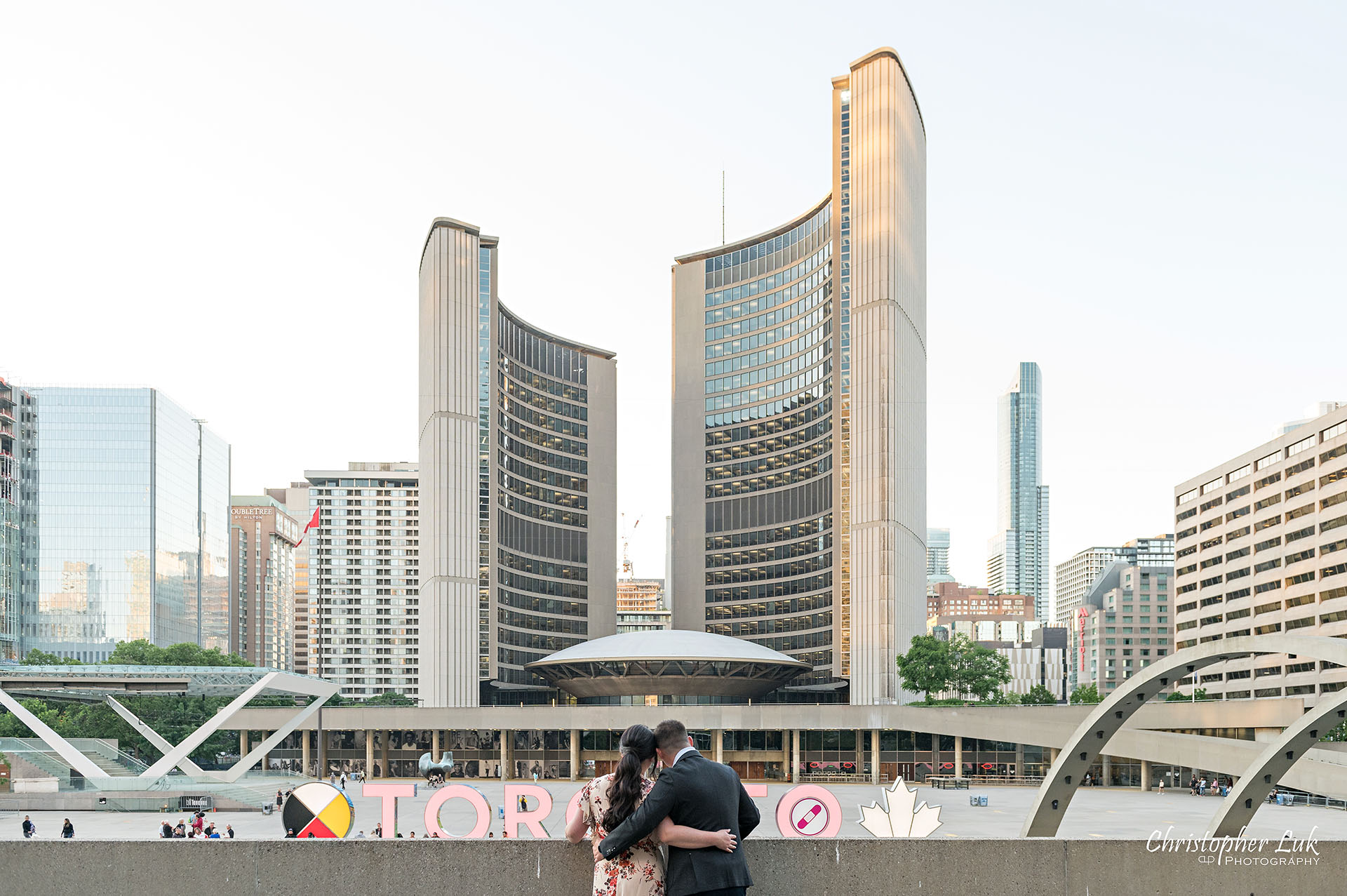 Christopher Luk Toronto Wedding Photographer Engagement Photos Pictures Session Osgoode Hall Nathan Philips Square City Hall Waterfall 3D Sign Bride Groom Hug Sunset Landscape