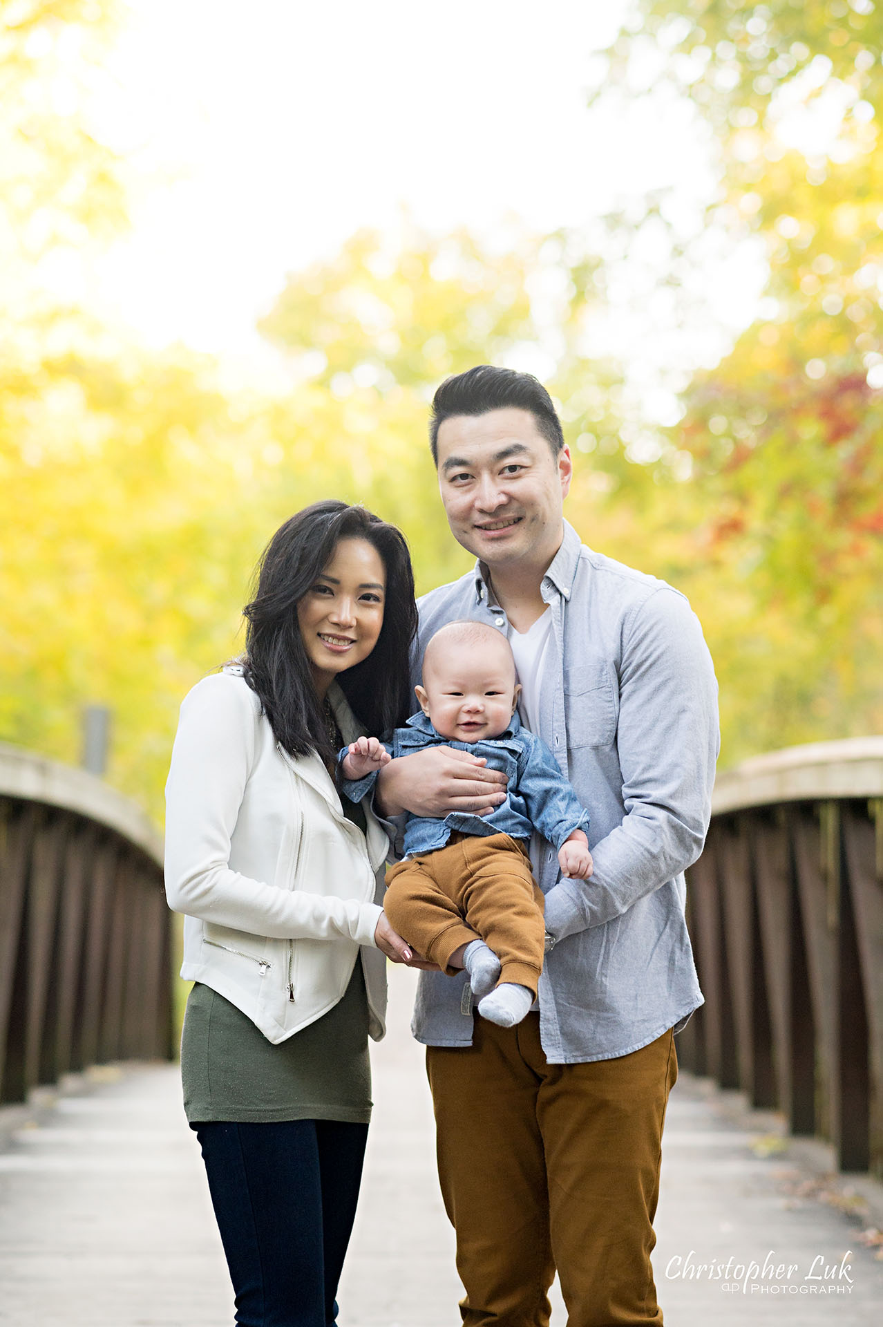 Mother Father Son Baby Smiling Portrait on Bridge Autumn Fall Leaves Markham Unionville Toronto Family Photographer