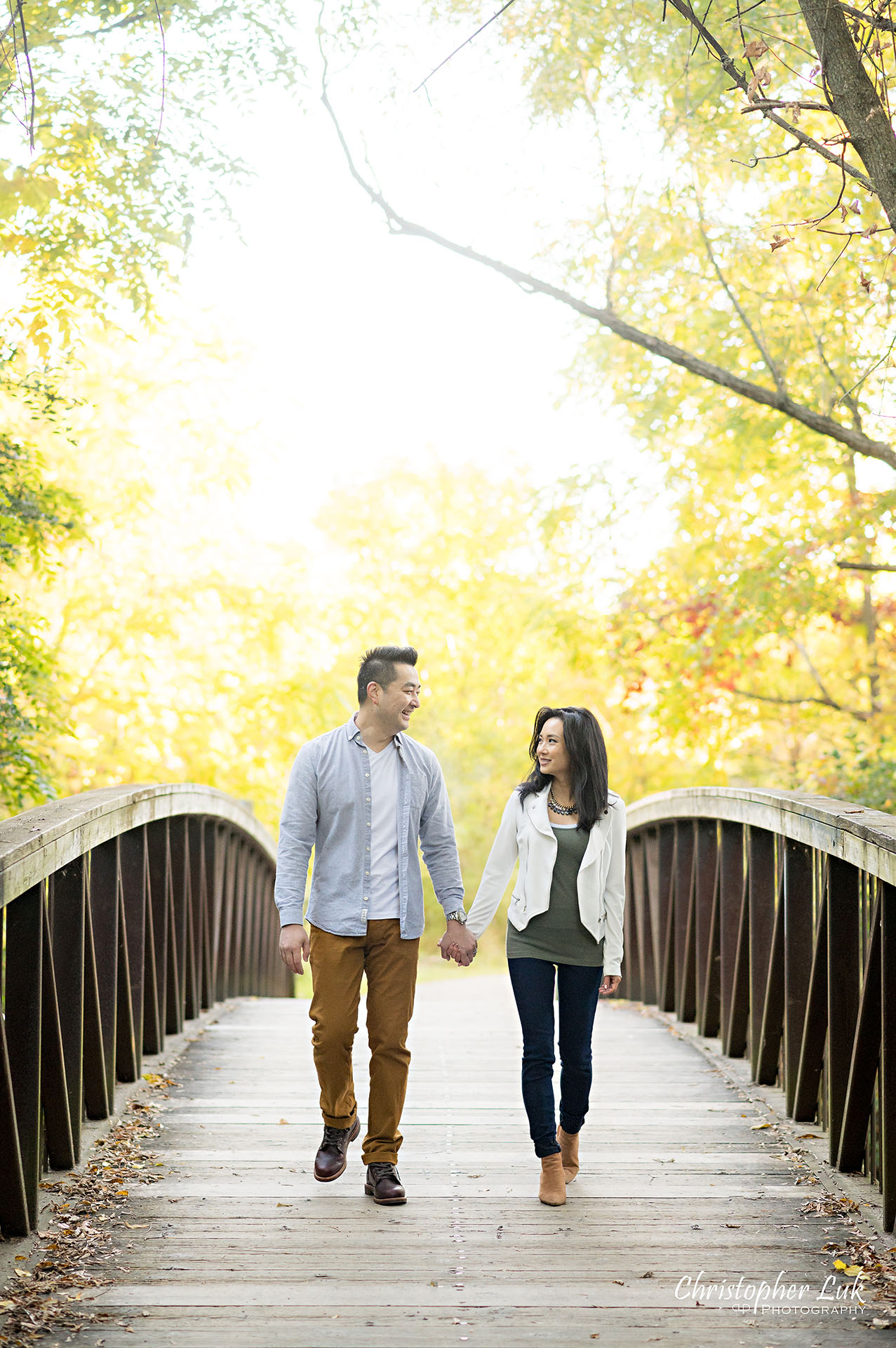 Mother Father Husband Wife Holding Hands Walking Together on Bridge Autumn Fall Leaves Markham Unionville Toronto Family Photographer