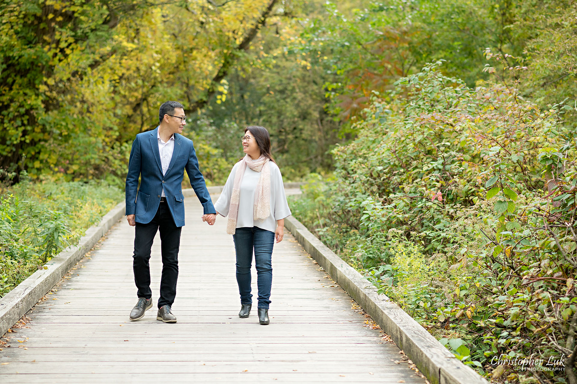 Father Mother Husband Wife Couple Holding Hands Walking Together Happy Landscape Main Street Unionville Markham Boardwalk Forest Toronto Family Photographer