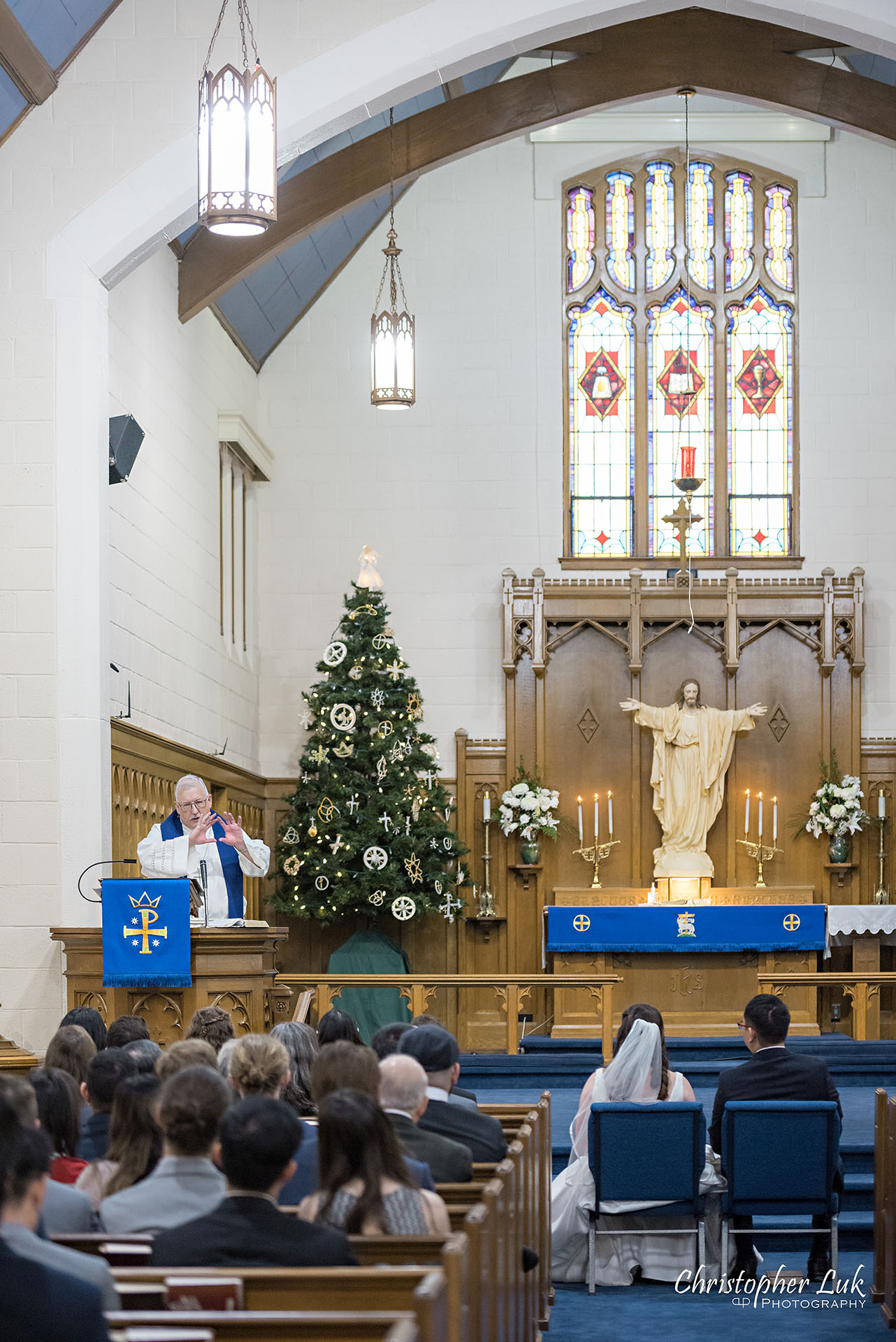 Wedding Ceremony Centre Aisle Kitchener Waterloo Church Interior Winter Stained Glass Windows Bride Groom Pastor Priest Officiant 