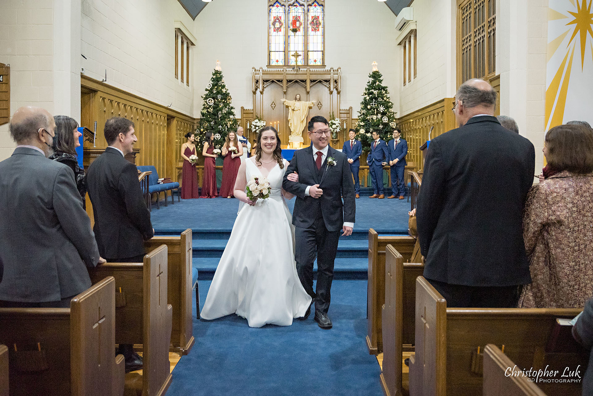 Wedding Ceremony Kitchener Waterloo Church Winter Stained Glass Windows Bride Groom Walking Down the Centre Aisle Together Recessional 