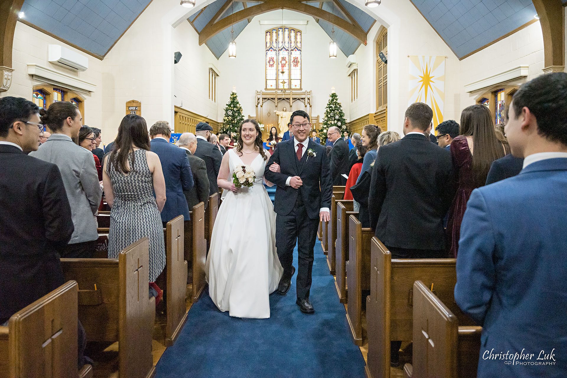 Wedding Ceremony Kitchener Waterloo Church Winter Stained Glass Windows Bride Groom Walking Down the Centre Aisle Together Recessional 
