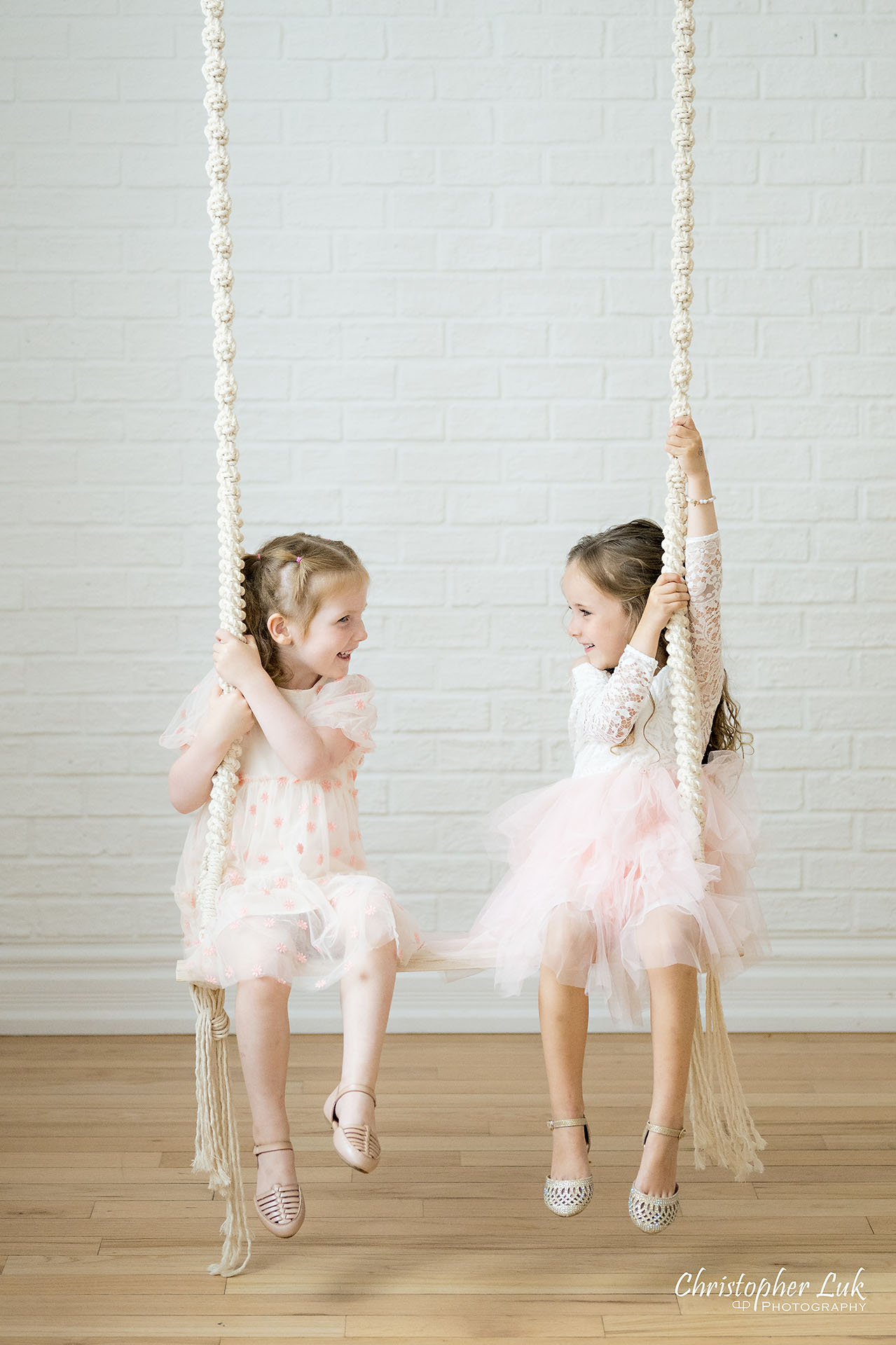 Cousins Sisters Daughters Girls White Pink Dresses Playing on Macrame Swing Portrait