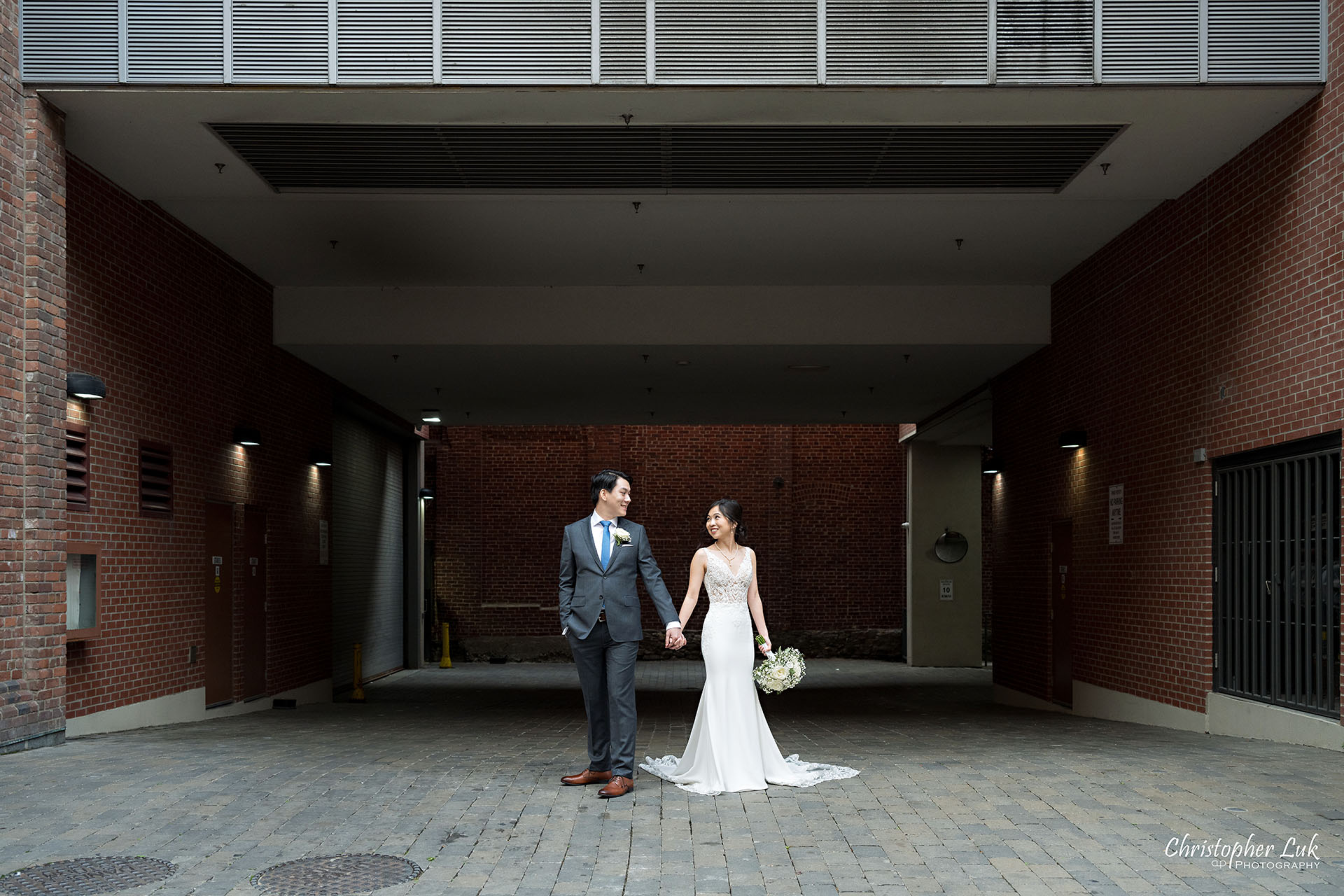 Bride Groom Wedding Holding Hands Walking Together Candid Natural Organic Photojournalistic Streetscape Downtown Toronto Front Street St Lawrence Market Architecture Red Brick Landscape