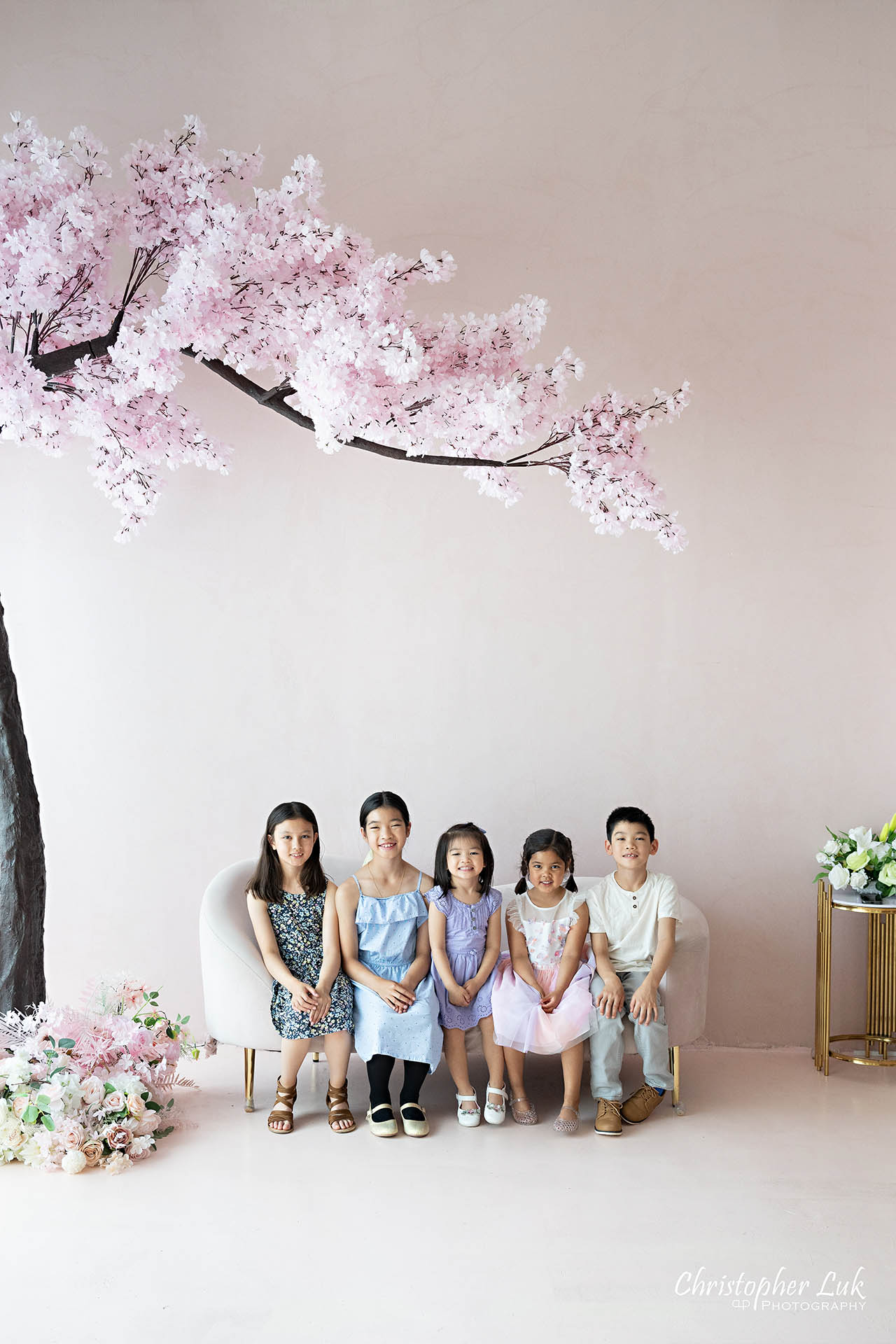 Grandchildren cousins children family photo Toronto natural light photography studio cherry blossoms pink flowers tree cute adorable portrait