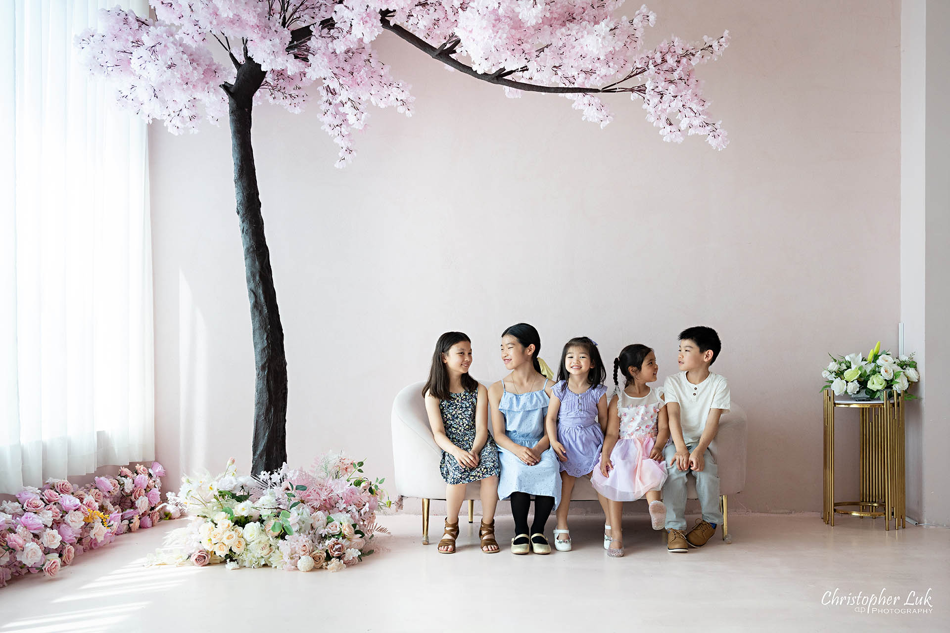 Grandchildren cousins children family photo Toronto natural light photography studio cherry blossoms pink flowers tree cute adorable hug