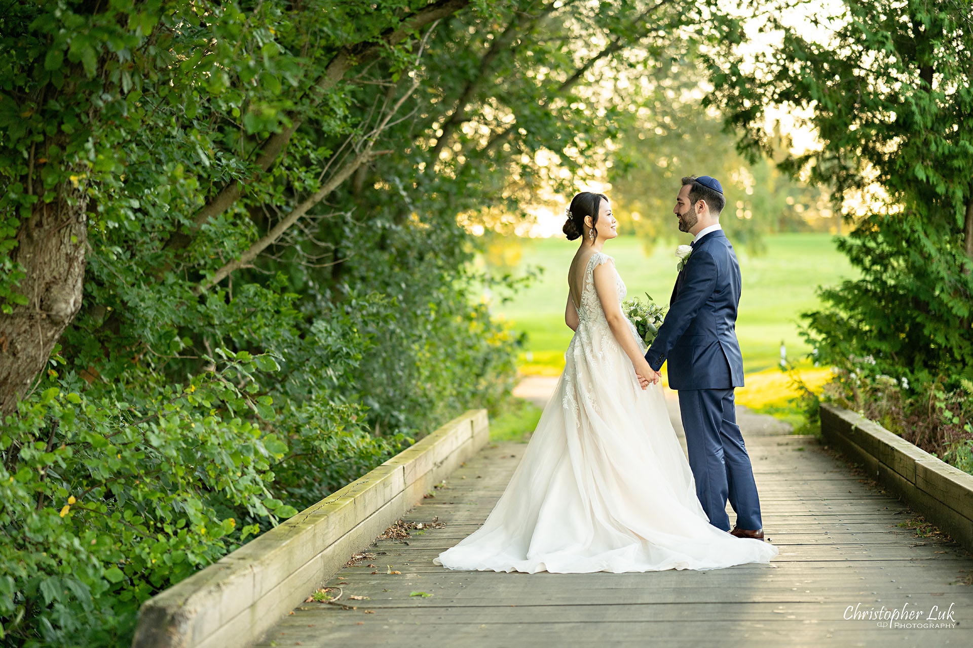 Angus Glen Golf Club Wedding Bride Groom Sunset Golden Hour Boardwalk Tree Canopy Holding Hands Smiling